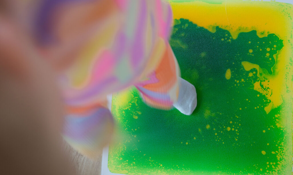 Mädchen steht auf einer Farbmatte