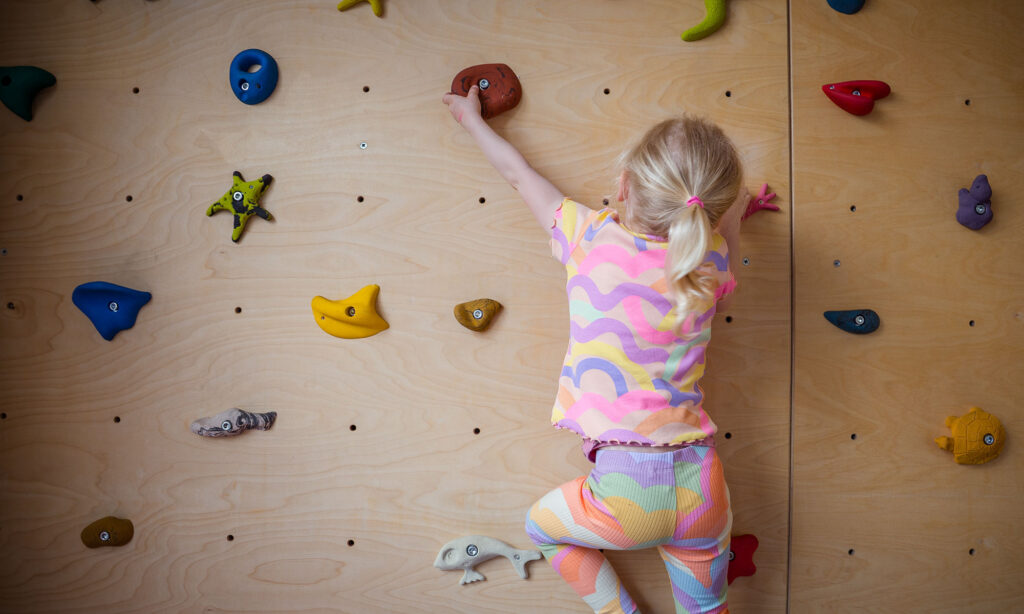 Mädchen klettert an der Kletterwand
